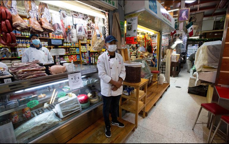 Dos vendedores usan mascarillas como medida de protección en un mercado de la Ciudad de México. AP/F. Llano