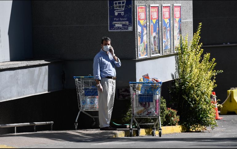 Una persona que porta una mascarilla habla por teléfono en las afueras de un supermercado, en Santiago, capital de Chile. XINHUA/J. Villegas