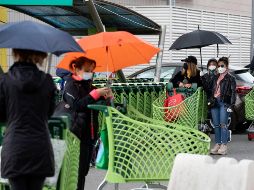 Varias personas esperan en fila a poder entrar en un supermercado de Roma. EFE/M. Percossi