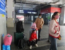 Una familia espera su tren en una estación de tren en Yichang, provincia de Hubei. EFE/L. Junfeng
