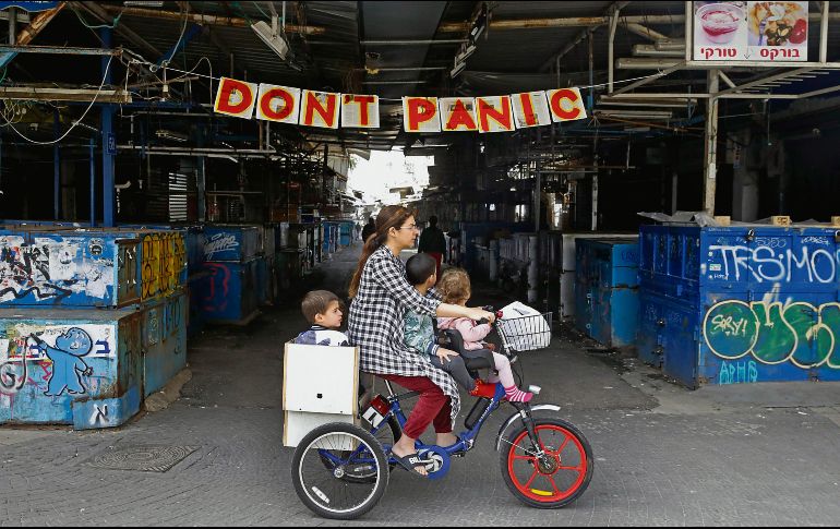 Una mujer pasea con sus hijos en Israel, país que activó el confinamiento social y cuenta con más de tres mil 600 contagios. AFP/J. Guez
