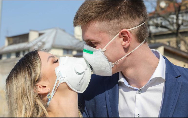 Una pareja se las arregla para demostrar sus sentimientos, luego de contraer nupcias en Vilna, Lituania. AFP/P. Malukas