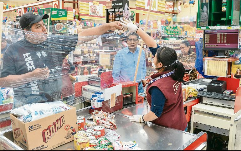 Una cajera aprovecha todos los recursos a su alcance para mantenerse alejada de clientes en una tienda del Estado de México. AFP/M. Vázquez