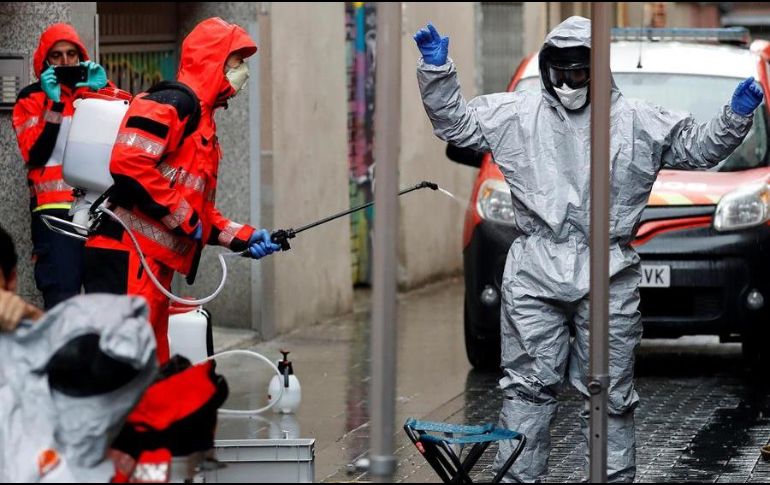 Un bombero de Barcelona desinfecta a un compañero tras salir de la residencia de religiosas del Colegio Sant Josep, donde se detectaron varios casos de coronavirus. EFE/A. Estévez