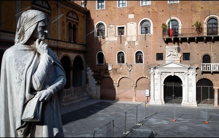 Una estatua del poeta italiano Dante Alighieri (i) se ve en una plaza desierta por el confinamiento en Verona, Italia. EFE/F. Venezia