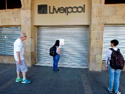Una mujer mira hoy el anuncio en una tienda cerrada en Guadalajara. AFP/U. Ruiz