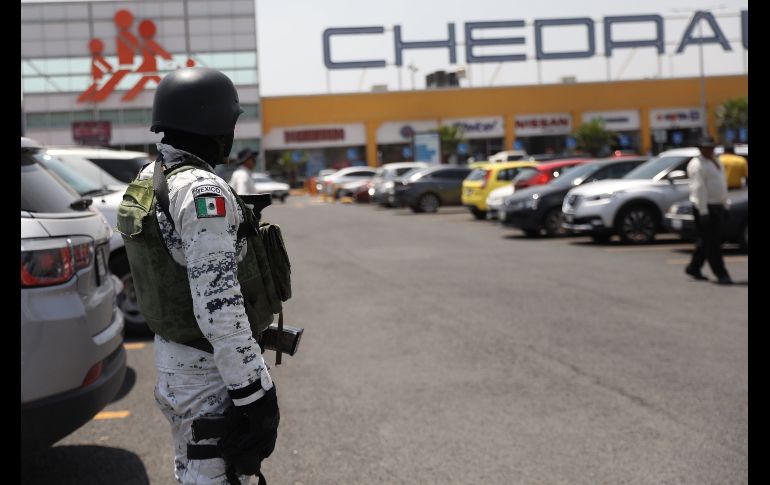 Un integrante de la Guardia Nacional vigilaba ayer afuera de un centro comercial en el municipio de Ojo de Agua, en el Estado de México, luego de saqueos registrados en la entidad. EFE/S. Gutiérrez