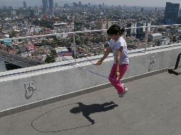Una niña brinca la cuerda en la azotea de un edificio en la Ciudad de México. Las actividades económicas y sociales regresarán de manera escalonada a partir del 30 de abril. AP / M. Ugarte