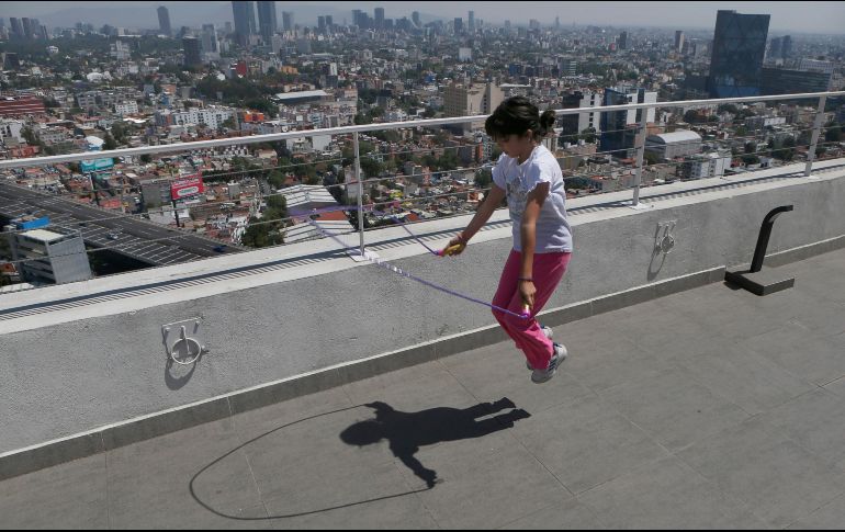 Una niña brinca la cuerda en la azotea de un edificio en la Ciudad de México. Las actividades económicas y sociales regresarán de manera escalonada a partir del 30 de abril. AP / M. Ugarte
