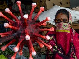 Un policía con un bastón con una figura de coronavirus realiza una campaña sobre la importancia de respetar las medidas para evitar los contagios en Chennai, India. AFP/A. Sankar