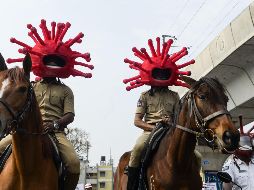 Policías con cascos en forma de coronavirus realizan una campaña sobre la importancia de respetar las medidas para evitar los contagios en Secunderabad, India. AFP/N. Seelam