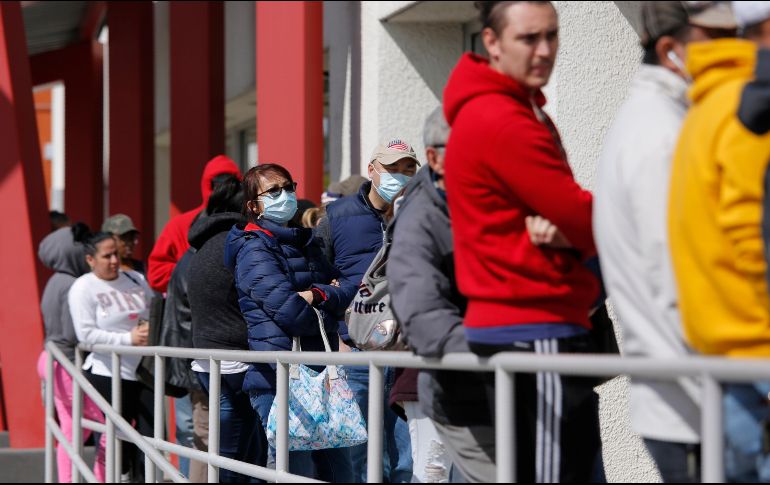 Personas en fila para tramitar el subsidio por desempleo. La semana pasada 6.64 millones solicitaron el apoyo. AP/J. Locher
