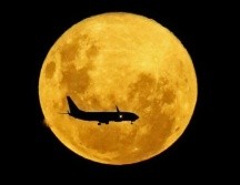 Un avión pasa por delante de la Luna, desde Curitiba, Brasil, el 9 de marzo de 2020. GETTY IMAGES