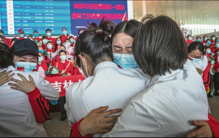 AEROPUERTO. Personal sanitario del Primer Hospital Bethune de la Universidad de Jilin se despide de sus colegas de Wuhan luego de que se levantó el bloqueo. EFE