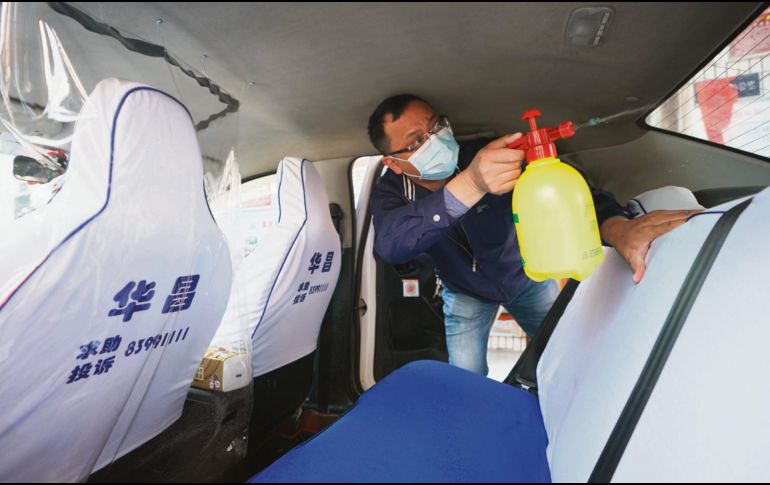 Nadie baja la guardia. Un trabajador del volante desinfecta su vehículo en una compañía de taxis en Wuhan, provincia de Hubei. XINHUA