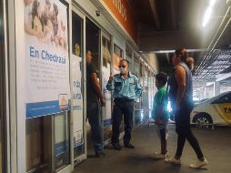 Un oficial a la entrada de una tienda Chedraui exhorta a que ingrese sólo un cliente por familia. EL INFORMADOR / G. Gallo