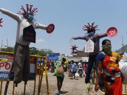 Autoridades indias se las ingenian para alertar sobre el coronavirus. Unos espantapájaros de COVID-19 llaman a quedarse en casa en un mercado de Chennai. AFP/A. Sankar