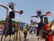 Autoridades indias se las ingenian para alertar sobre el coronavirus. Unos espantapájaros de COVID-19 llaman a quedarse en casa en un mercado de Chennai. AFP/A. Sankar