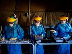 Trabajadores llenan formularios antes de realizar pruebas de  COVID-19 a personal de salud en un hospital en Johannesburgo, Sudáfrica. AFP/M. Spatari