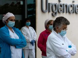 Personal médico afuera de un hospital en Valencia participa en un homenaje de tres minutos de silencio por las víctimas del coronavirus. AFP/J. Jordan