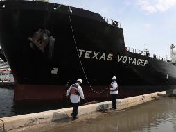 Trabajadores ayudan hoy a atracar un buque petrolero en Fort Lauderdale, Florida. La extracción de petróleo continúa ante la baja demanda, por lo que se están saturando los lugares de almacenamiento. AFP/J. Raedle