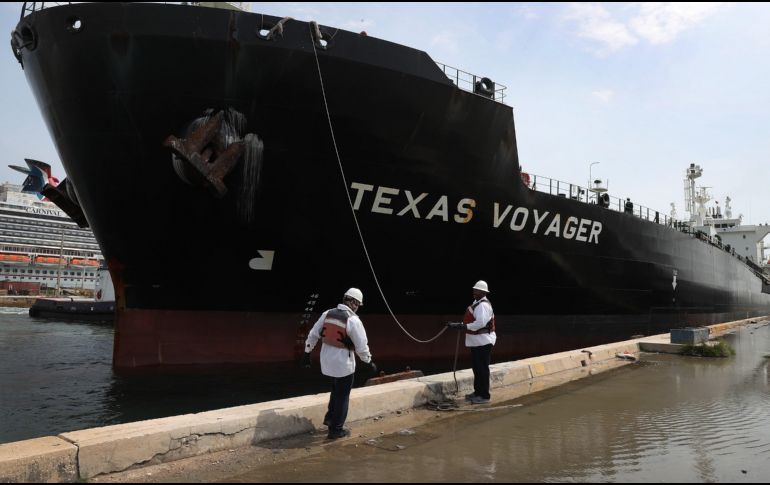 Trabajadores ayudan hoy a atracar un buque petrolero en Fort Lauderdale, Florida. La extracción de petróleo continúa ante la baja demanda, por lo que se están saturando los lugares de almacenamiento. AFP/J. Raedle