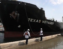 Trabajadores ayudan hoy a atracar un buque petrolero en Fort Lauderdale, Florida. La extracción de petróleo continúa ante la baja demanda, por lo que se están saturando los lugares de almacenamiento. AFP/J. Raedle
