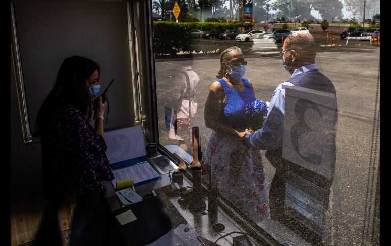 Los funcionarios conducen la ceremonia desde el interior de una cabina, instalada en un estacionamiento del Centro Honda. La boda de Natasha y Michael Davis. AFP/A. Gomes