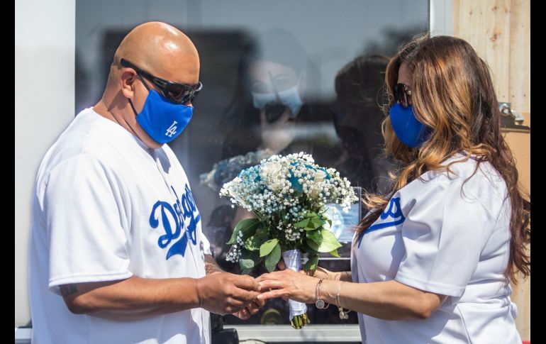 Philip Hernandez le pone el anillo a su novia Marcela Peru durante una boda el martes en Anaheim, California. AFP/A. Gomes