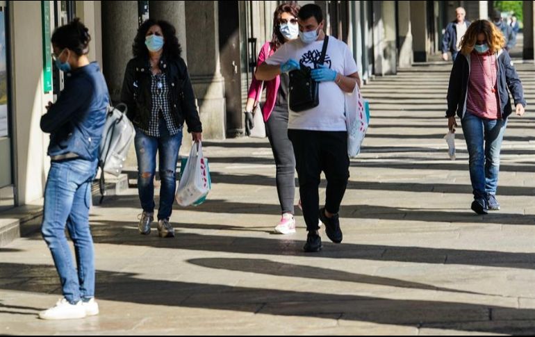 Algunas personas con cubrebocas caminan por calles de Turín, Italia. EFE/T. Romano