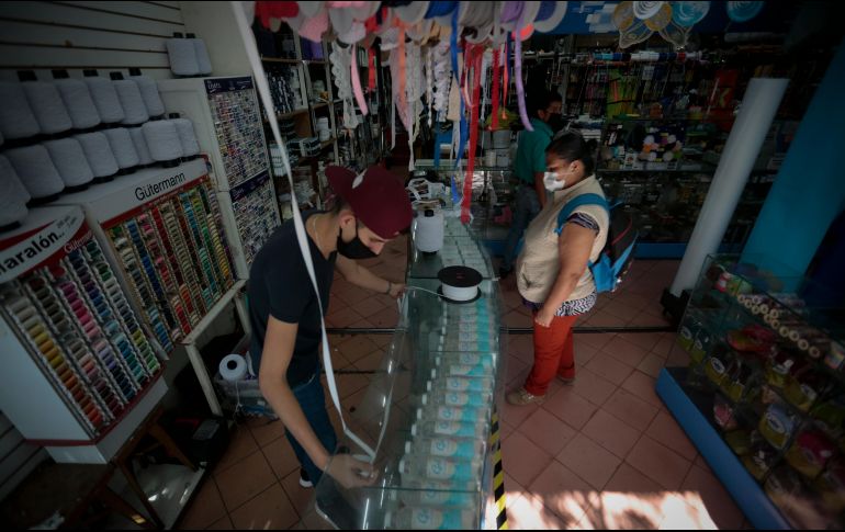 Para no recibir una sanción del Ayuntamiento de Guadalajara, una mercería del Centro decidió que sus clientes tomaran “sana distancia” entre ellos para evitar aglomeraciones; el negocio sólo permite entrar a uno o dos a la vez. EL INFORMADOR/F. Atilano