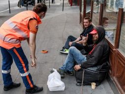 Voluntarios reparten comida a personas sin hogar en París en medio de las medidas de confinamiento para evitar contagios. EFE/C. Petit