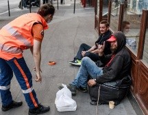 Voluntarios reparten comida a personas sin hogar en París en medio de las medidas de confinamiento para evitar contagios. EFE/C. Petit
