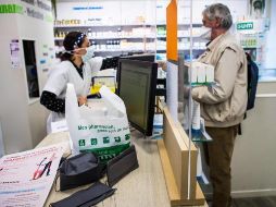 Un hombre realiza unas compras en una farmacia ubicada en París, este lunes. EFE/C. Petit