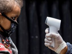 Un trabajador sanitario nepalés controla la temperatura de un niño durante la campaña nacional de vacunación en el centro de salud Ramghaat, en Katmandú. EFE/N. Shrestha