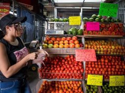 Una vendedora de hortalizas trabaja en un local de venta de alimentos en un mercado popular, en Caracas. EFE/M. Gutiérrez