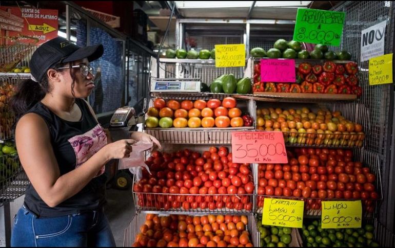 Una vendedora de hortalizas trabaja en un local de venta de alimentos en un mercado popular, en Caracas. EFE/M. Gutiérrez