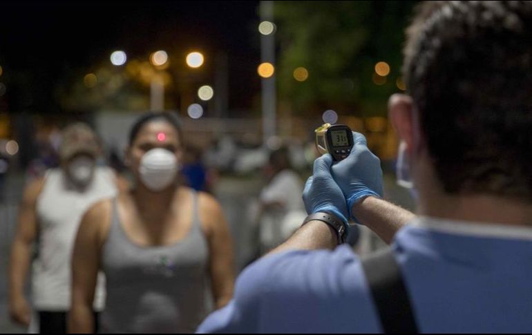 Un doctor toma la temperatura a una mujer como medida de prevención ante el coronavirus, el pasado sábado, durante una velada de boxeo en Managua. EFE/J. Torres