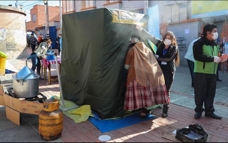 Una mujer aimara ingresa una cámara de medicina tradicional, donde usan plantas de eucalipto, manzanilla y huira huira para tratar enfermedades respiratorias, en El Alto. EFE/M. Alipaz
