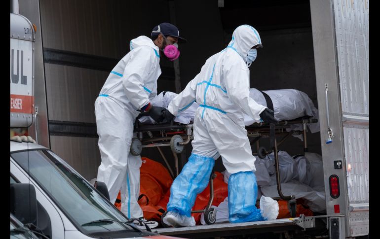 Trabajadores trasladan cuerpos a un tráiler refrigerado afuera de la funeraria en Brooklyn. AP/C. Ruttle