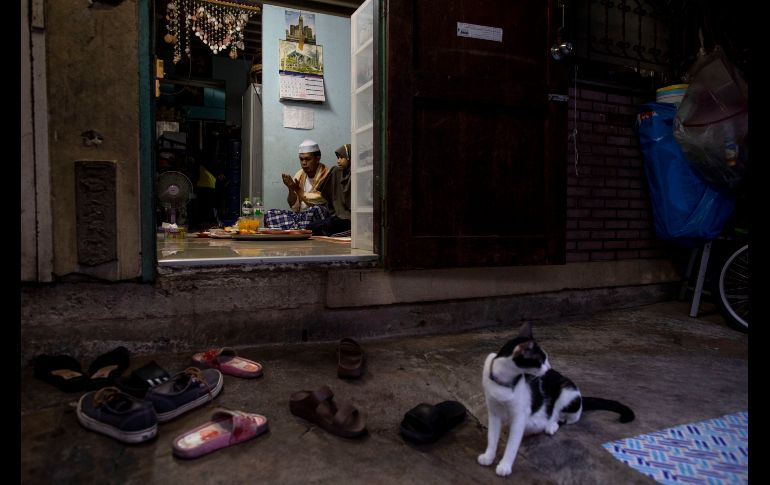Una familia ora en su casa antes de romper el ayuno en Bangkok, Tailandia. AP/G. Amarasinghe