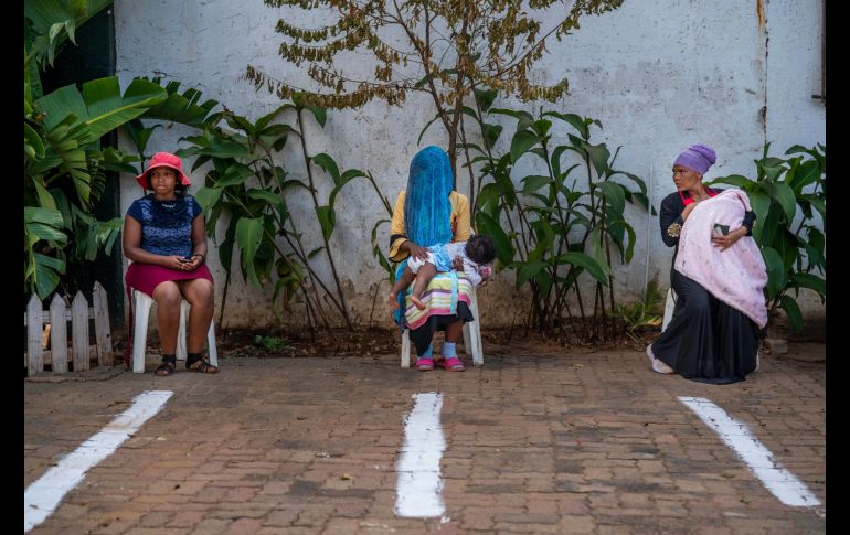 Frente a la mezquita Imán Ahmed Raza Jaame Masjid en Springs, al suroeste de Johannesburgo, tres mujeres aguardaban las golosinas del Ramadán, cada una en su silla apartada de las demás en espacios señalados con pintura blanca. AP/J. Delay
