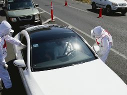 SUPERVISIÓN. El viernes, en los tres filtros sanitarios ubicados en las vías hacia Chapala, Puerto Vallarta y Manzanillo, las autoridades revisaron aleatoriamente a siete mil 023 personas que circulaban en dos mil 621 autos.  AFP