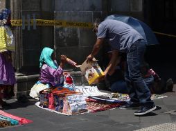 La iniciativa de los comerciantes fue difundida en redes sociales, por lo que en poco tiempo acudieron personas con toda clase de artículos de primera necesidad. EFE/S. Gutiérrez