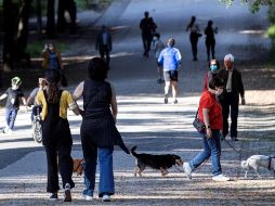 Varias personas sacan a pasear a sus mascotas; las medidas de protección como el uso de cubrebocas son obligatorias. EFE/M. Percossi
