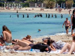 Varias personas toman el sol y nadan en el mar en la playa de Mondello, una larga costa arenosa, en Palermo, Italia. EFE/I. Petyx