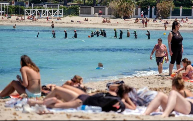Varias personas toman el sol y nadan en el mar en la playa de Mondello, una larga costa arenosa, en Palermo, Italia. EFE/I. Petyx