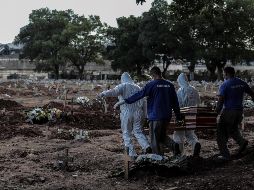 Empleados de una funeraria trasladan un cuerpo en el cementerio de Caju, en Río de Janeiro. Ayer, Brasil tuvo 751 defunciones en un día y es sexto en el mundo por el número de fallecimientos. EFE/A. Lacerda