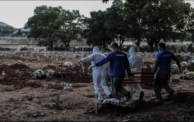 Empleados de una funeraria trasladan un cuerpo en el cementerio de Caju, en Río de Janeiro. Ayer, Brasil tuvo 751 defunciones en un día y es sexto en el mundo por el número de fallecimientos. EFE/A. Lacerda