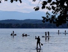 Personas acuden este domingo al lago Starnberger, frente a la montaña más alta de Alemania, Zugspitze, cerca de la ciudad de Seeshaupt. AP/M. Schrader